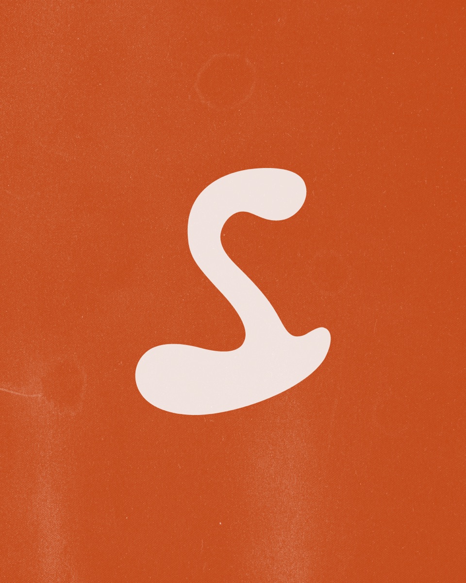 Isotipo de Sazón, la S cursiva en crema, sobre un fondo naranja con textura de papel